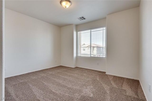 carpeted spare room with visible vents and baseboards