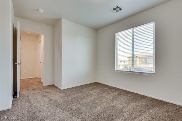 carpeted spare room with visible vents and baseboards