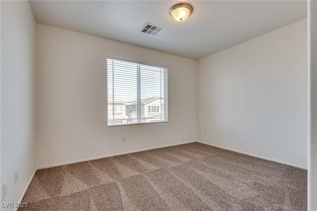 spare room with carpet floors, visible vents, and baseboards