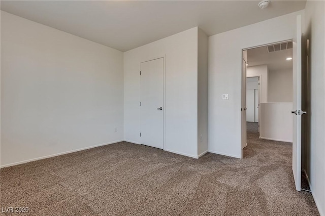 unfurnished bedroom with carpet, visible vents, and baseboards