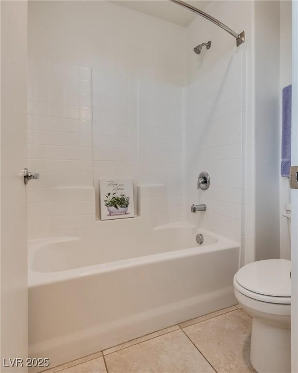 full bath featuring bathing tub / shower combination, tile patterned flooring, and toilet