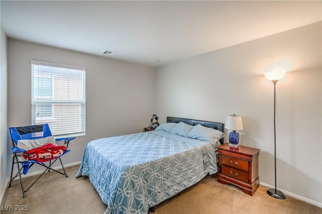 carpeted bedroom featuring baseboards and visible vents