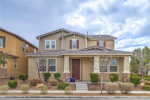 craftsman-style home with stucco siding, stone siding, a porch, and a tiled roof