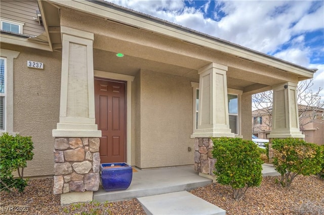 property entrance with stone siding and stucco siding