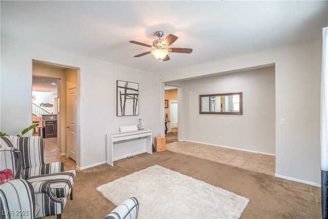 living area with baseboards, a ceiling fan, and carpet flooring