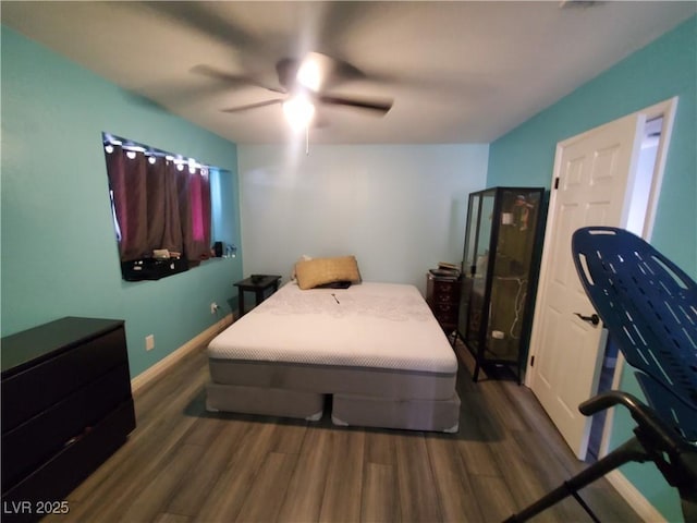 bedroom featuring ceiling fan, baseboards, and wood finished floors