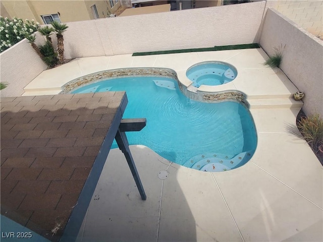 view of pool with a fenced backyard and an in ground hot tub