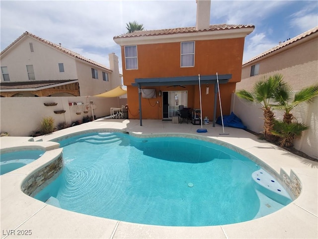 rear view of house featuring a pool with connected hot tub, a fenced backyard, a patio, and stucco siding