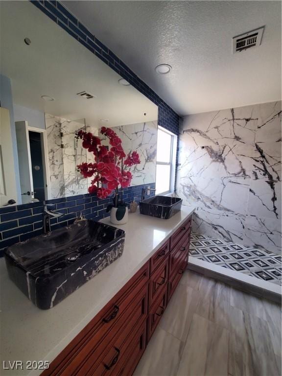 kitchen with tasteful backsplash, visible vents, dark brown cabinets, and a sink