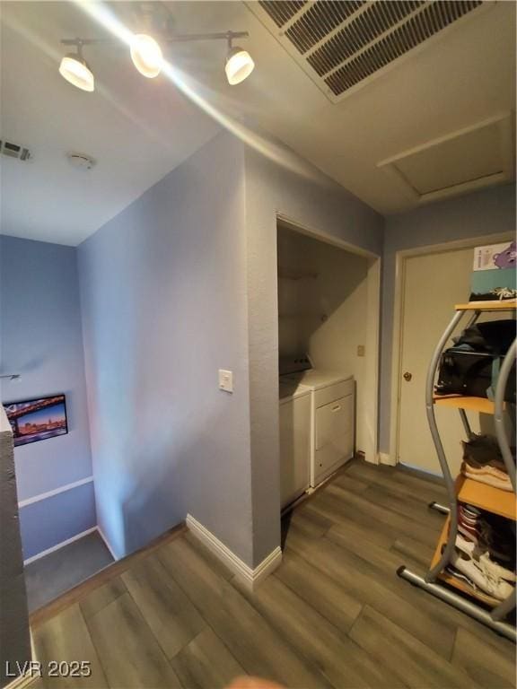 hall with baseboards, washing machine and dryer, visible vents, and wood finished floors