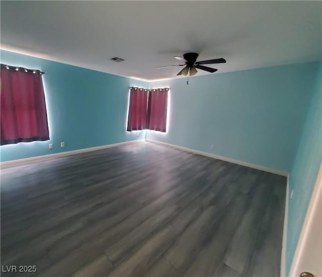 unfurnished room with baseboards, visible vents, ceiling fan, and wood finished floors