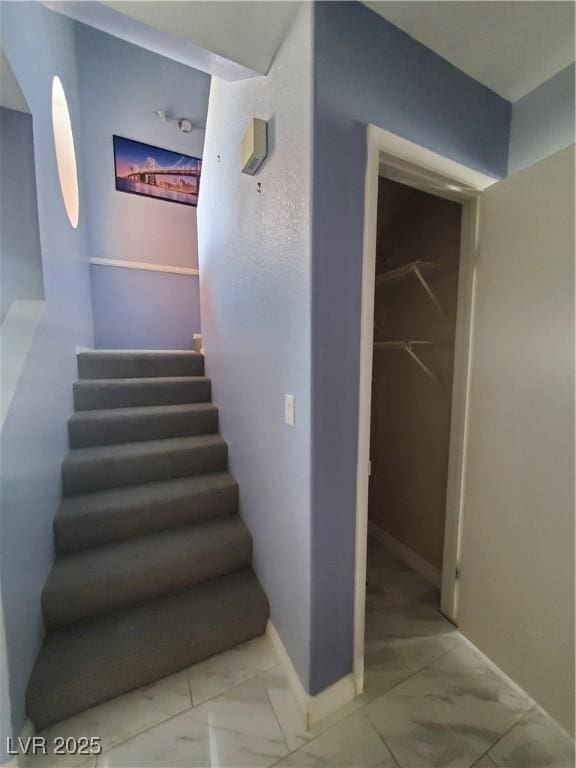 stairs with marble finish floor and baseboards