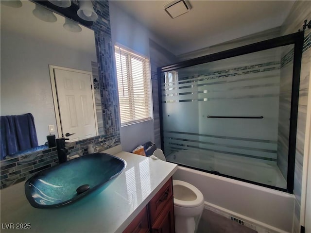 full bath featuring toilet, combined bath / shower with glass door, vanity, and tasteful backsplash