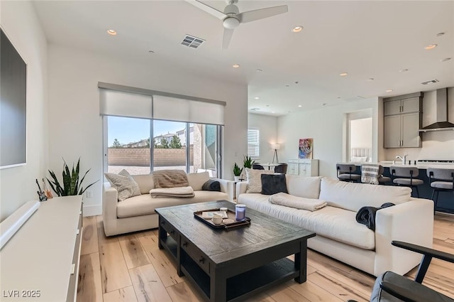 living room featuring a ceiling fan, recessed lighting, visible vents, and light wood-type flooring