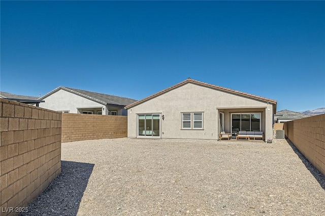 back of house with stucco siding, central AC unit, and a fenced backyard