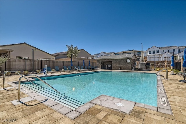 community pool featuring a residential view, a patio, and fence