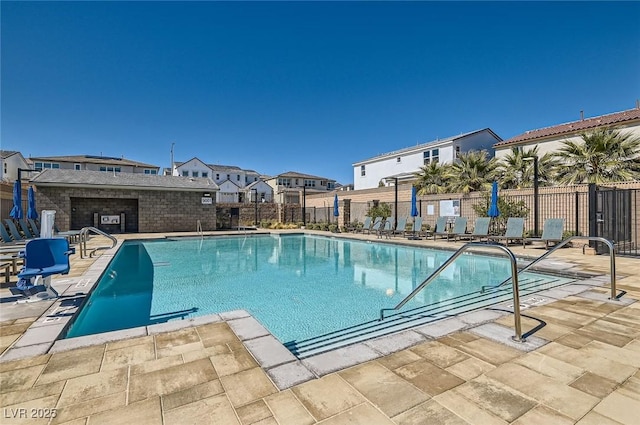 pool featuring a residential view, a patio, and fence