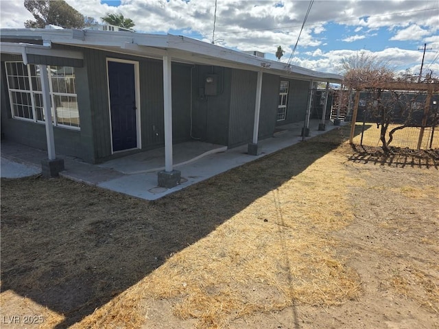 rear view of property with fence and a patio