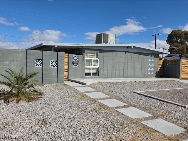 back of property with fence and central AC