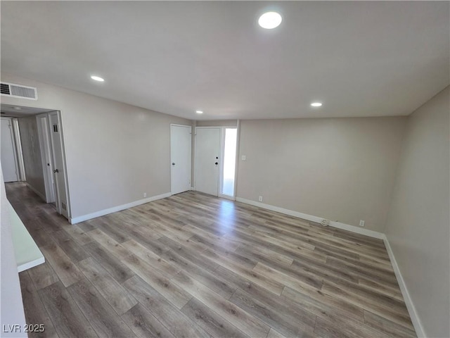 unfurnished room with visible vents, baseboards, wood finished floors, and recessed lighting