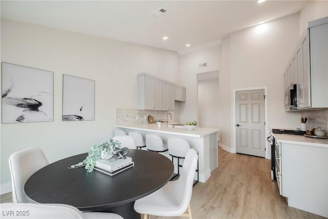 dining space featuring recessed lighting, visible vents, light wood-style flooring, and baseboards