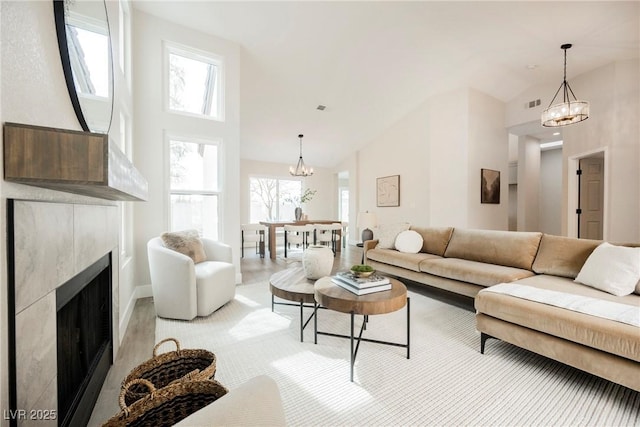 living room with high vaulted ceiling, a fireplace, and a healthy amount of sunlight