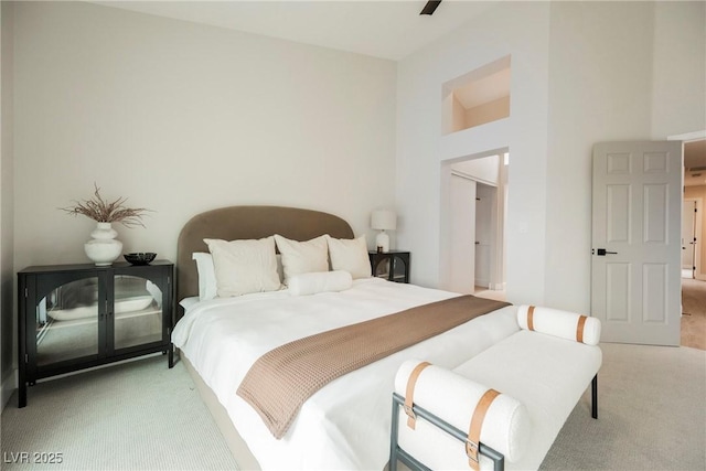 bedroom with light carpet and a towering ceiling