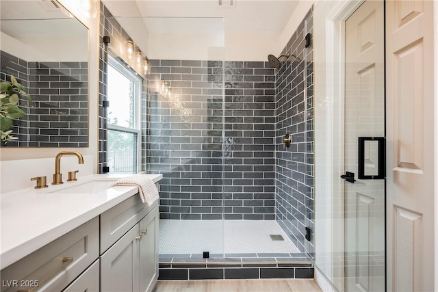 full bath with a shower stall and vanity