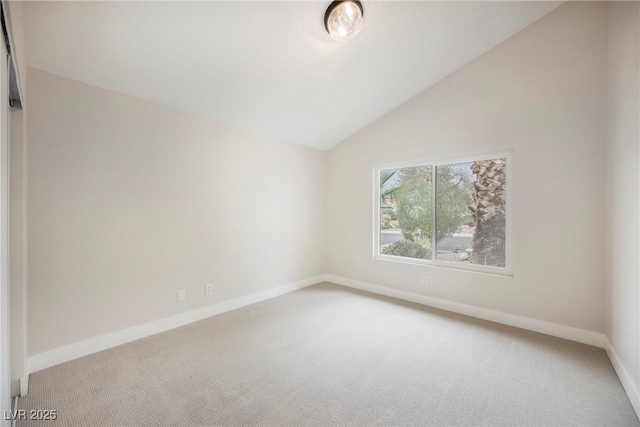 unfurnished room with light carpet, vaulted ceiling, and baseboards