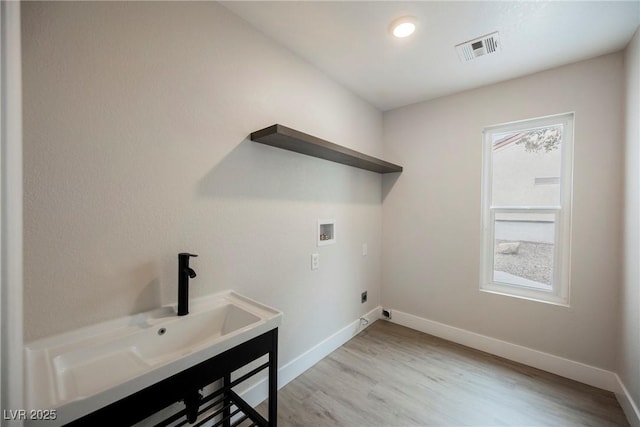 laundry area featuring washer hookup, visible vents, light wood-style floors, laundry area, and baseboards