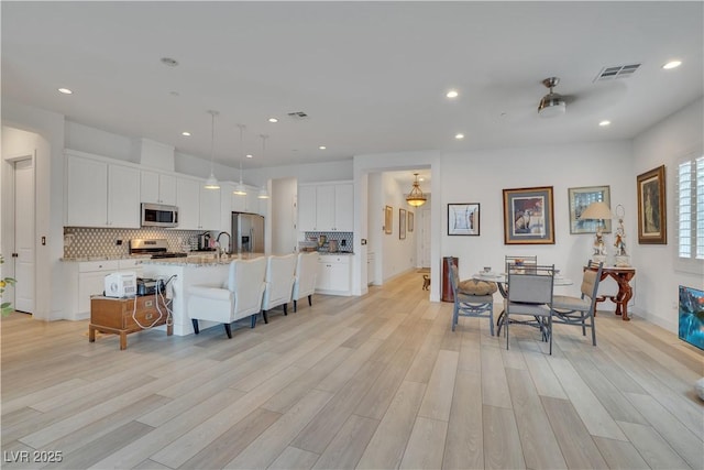 interior space featuring recessed lighting, visible vents, and light wood finished floors