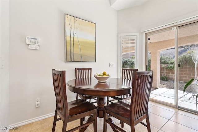 dining space featuring light tile patterned floors and baseboards