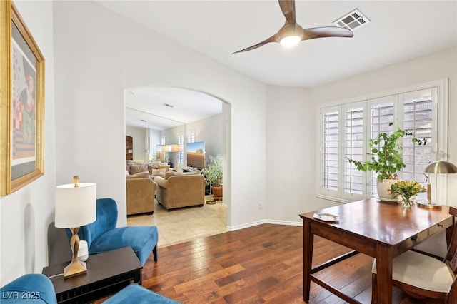 office featuring arched walkways, ceiling fan, visible vents, baseboards, and hardwood / wood-style floors