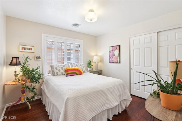 bedroom featuring a closet, dark wood-style flooring, and visible vents