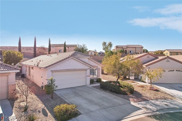 view of front facade with driveway, a tiled roof, an attached garage, and stucco siding