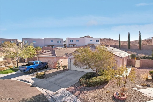 view of front of property featuring an attached garage, a tile roof, concrete driveway, and stucco siding