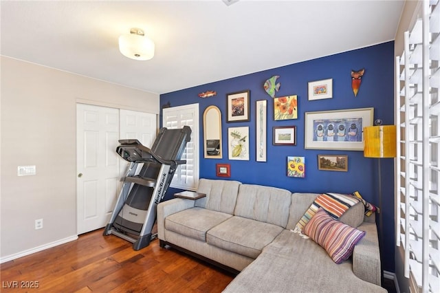 workout area with baseboards and wood finished floors