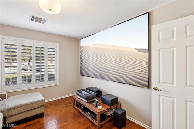 living area with visible vents, baseboards, and hardwood / wood-style flooring