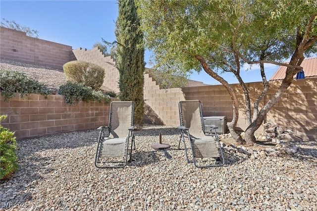 view of yard with central air condition unit, a fenced backyard, and a patio