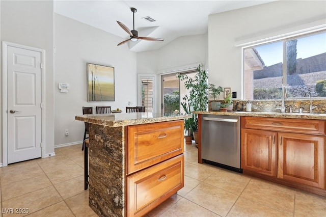 kitchen with light tile patterned floors, visible vents, light stone counters, stainless steel dishwasher, and a sink