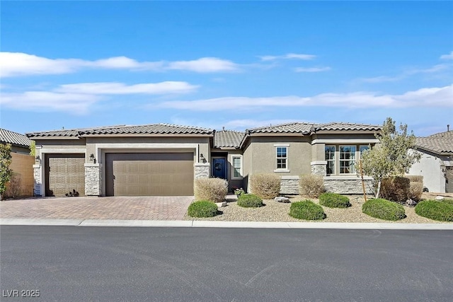 view of front of home featuring stone siding, an attached garage, and stucco siding