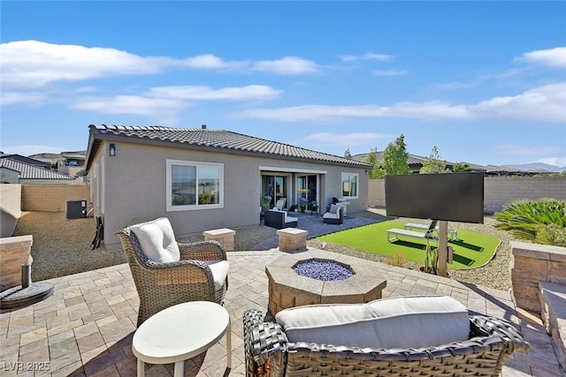 back of property featuring an outdoor living space with a fire pit, a tiled roof, fence, a patio area, and stucco siding