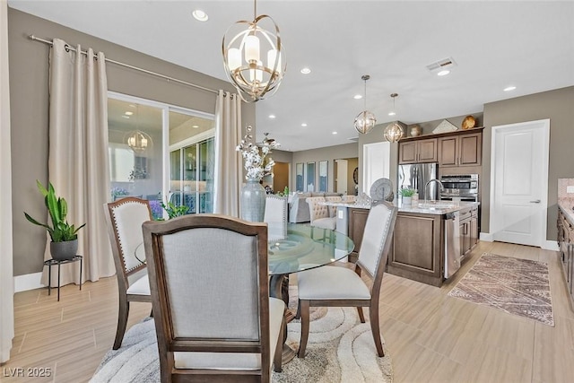 dining room with an inviting chandelier, light wood-style flooring, visible vents, and recessed lighting