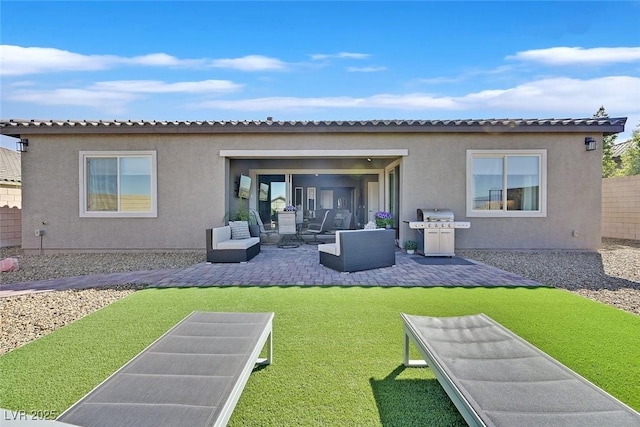 back of property with a lawn, a patio, fence, an outdoor living space, and stucco siding