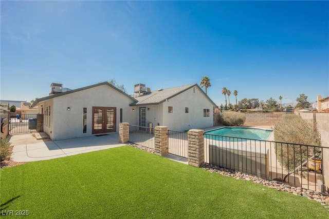 6284 Pinewood Ave, Las Vegas, NV 89103 - back of house featuring fence, french doors, a lawn, stucco siding, and a patio area