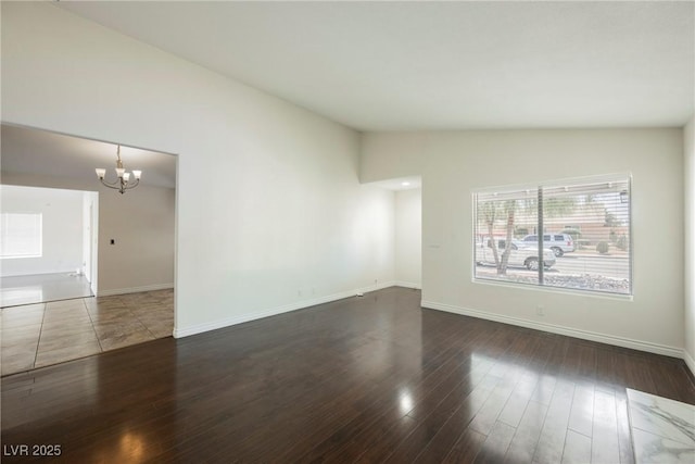6284 Pinewood Ave, Las Vegas, NV 89103 - unfurnished room with a notable chandelier, vaulted ceiling, baseboards, and wood finished floors
