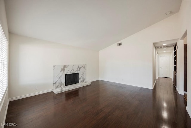 6284 Pinewood Ave, Las Vegas, NV 89103 - unfurnished living room featuring a premium fireplace, visible vents, baseboards, vaulted ceiling, and dark wood-style floors