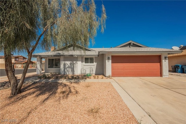 ranch-style house featuring a garage, concrete driveway, and stucco siding