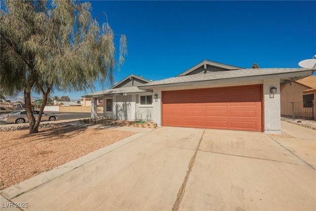 ranch-style house featuring driveway, an attached garage, and stucco siding