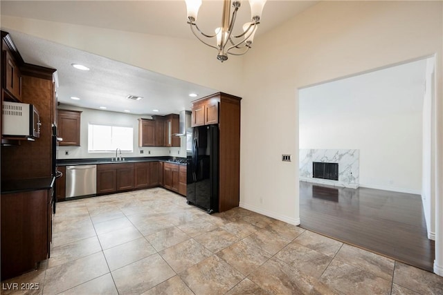 6284 Pinewood Ave, Las Vegas, NV 89103 - kitchen with freestanding refrigerator, wall chimney range hood, a chandelier, stainless steel dishwasher, and a high end fireplace